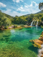 Naklejka na ściany i meble Serene waterfall in a lush green forest landscape - This serene image captures a majestic waterfall flowing into a crystal-clear pond surrounded by greenery