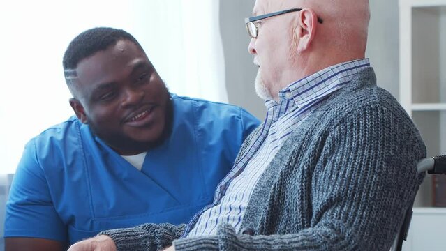 African-American caregiver and old man. Professional nurse and patient in a nursing home. Assistance, rehabilitation and health care concept.