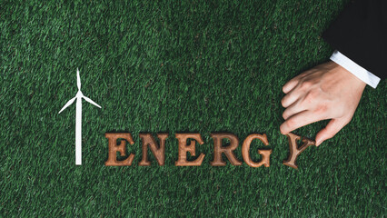 Hand arrange wooden alphabet in ECO awareness campaign on biophilia green grass background o...