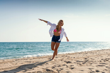 Beautiful young woman enjoying freedom while having fun at the beach - 790400455