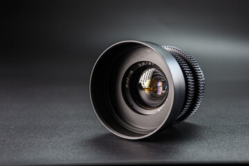 Precision-engineered camera lens angled to show reflections, details of aperture marking 2.8 37...