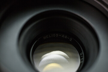 Looking through a Helios 44-2 camera lens, engraved branding on inner rim, highlighting the subtle...