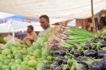 Different vegetables in street market and bazaar with vendors in background