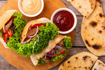 Pita with salad , paprika and beef meat . Traditional arabian and israel food