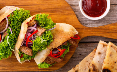 Pita with salad , paprika and beef meat . Traditional arabian and israel food