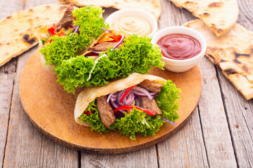 Pita with salad , paprika and beef meat . Traditional arabian and israel food