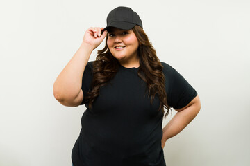 Mockup shot of a big woman wearing a black cap and t-shirt against a white background in a studio - 790416237