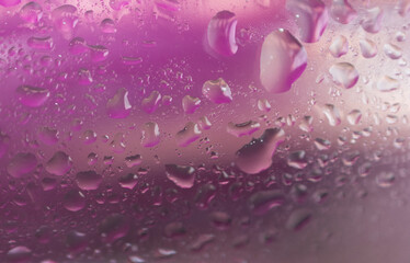 Water drops on pink background and light reflections. Space for text. Abstract wallpaper