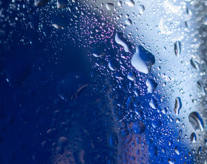 Square photo in blue tones with water drops and light reflections. Abstract background