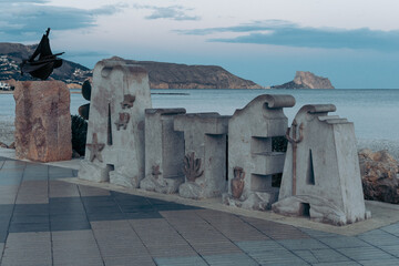 Stone block of the seafront promenade with the name of a Spanish coastal town. In the letters it says in Spanish "Altea".