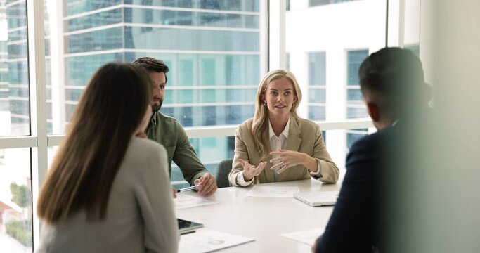 Group of business partners negotiate in boardroom, listen speech of female boss talking about company strategic direction, upcoming projects, financial performance, market opportunity, corporate goals
