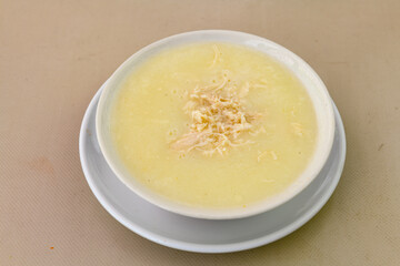 Homemade turkish soup Tavuk Suyu corbasi in a white ceramic soup plate.Turkish noodle chicken broth soup on a plate. Turkish meal (sehriyeli tavuk suyu corbasi)