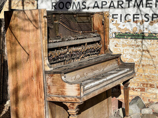 worn out piano outside on the street