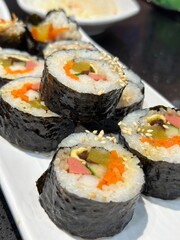 Gimbap  is a Korean dish made from cooked rice, vegetables, fish, and meat rolled in gim