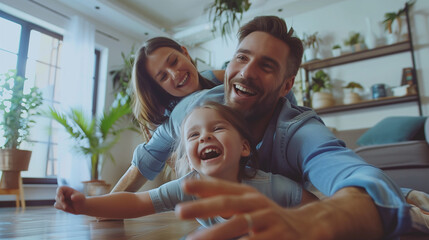 Father, Mother and Daughter Sharing Smiles While Rolling on the Floor