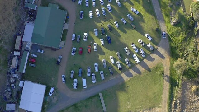 Drone, cars at outdoor theater and nature with pathway or road, buildings and green landscape. Parking lot, transport with film entertainment in countryside and aerial view of trees with vehicles