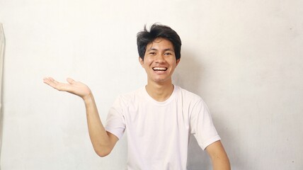 Young Asian man in a white shirt poses showing his palms