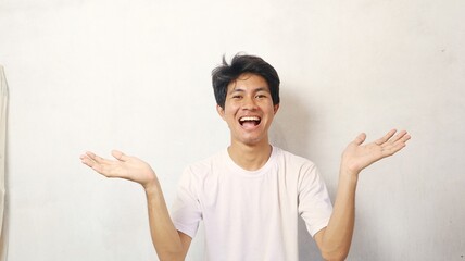 Young Asian man in a white shirt poses showing his palms