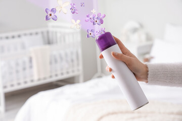 Woman with air freshener in bedroom, closeup
