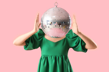 Beautiful stylish woman with disco ball on pink background