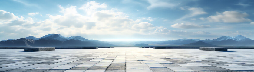 An empty stone plaza with snow capped mountains in the distance