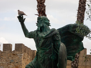 Statue of the founder of the city of Badajoz located in the gardens of the Alcazaba. A turtledove...