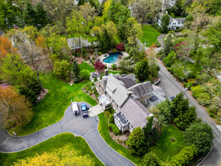 This drone-captured image offers a stunning overview of a prosperous neighborhood in Millburn, NJ,...