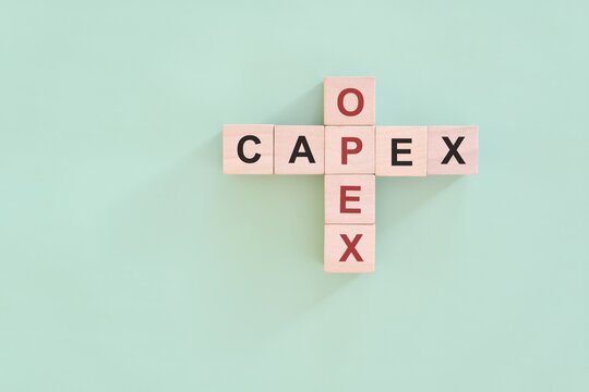 CAPEX versus OPEX concept. Crossword puzzle flat lay composition.