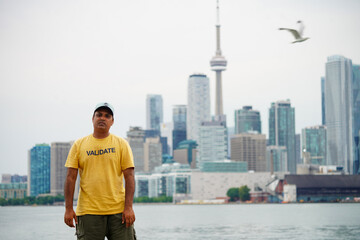 A young man is standing in Toronto's Skylines, Ontario. Canada