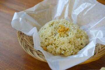Lime leaf rice on wooden table. Fried onion on top. thisi is Indonesian cuisine on rattan plate....