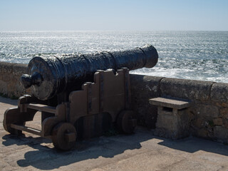 Vintage cannon looking out over ocean from fort walls