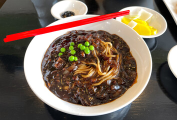 A bowl of Jajangmyeon, a popular Korean dish or noodles in a thick black bean sauce.