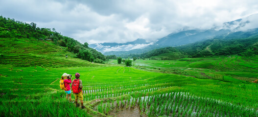 Lover asian man asian women travel nature Travel relax Walking a photo on the rice field in rainy...