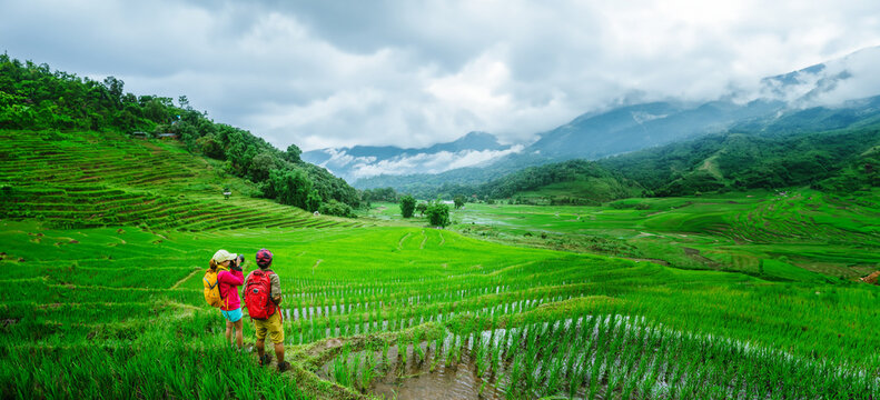Lover asian man asian women travel nature Travel relax Walking a photo on the rice field in rainy season in Chiang Mai, Thailand