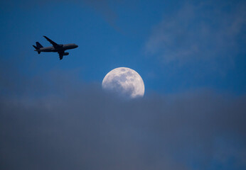 Commercial Airliner at Sunset Passes By Moon