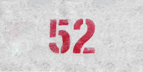 Red Number 52 on the white wall. Spray paint.