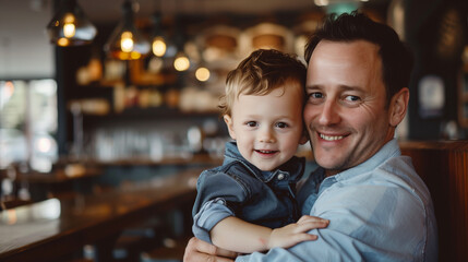 Portrait of a Father Holding His Son in a Restaurant. 