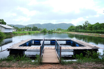 Naklejka na ściany i meble Natural freshwater fish farming cages in Thailand