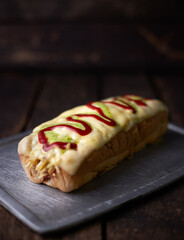 A long hot dog with mustard and ketchup on it
