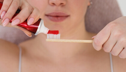 Applying toothpaste to bamboo brush.