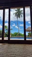 Urlaub in Afrika - Haus mit Pool und Palmen - mit Blick aus einem Ferienhaus