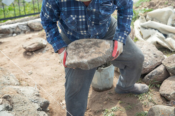 Craftsman working in rough stones in outdoor.