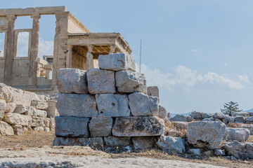 Large stones block view of the Caryatids statues on the south porch of the Erechtheion temple at the Acropolis in Athens Greece