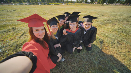 College alumni take selfies in the meadow.
