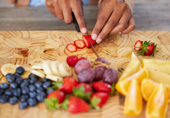 Hands, fruit and cutting on board in kitchen, nutrition and fresh or raw food for detox in home....