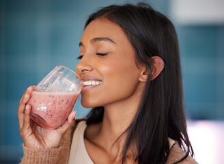 Indian woman, smile and drinking smoothie for health, nutrition and juice for detox in home. Female person, drink and organic ingredients for vegan diet, vitamins and minerals in protein shake - obrazy, fototapety, plakaty