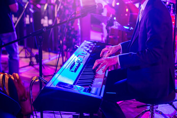 Young man musician playing electric piano in concert performance.
