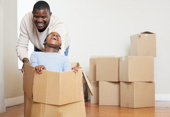 Black man, child and playing with box in new home for moving, relocation or property together....