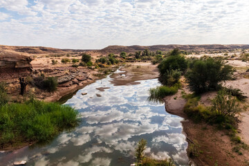 Low scattered clouds are reflected in the Fish River in Southern Namibia