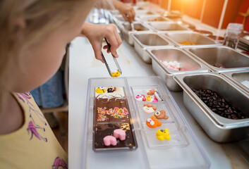 Baby girl in the workshop during a lesson on making handmade chocolates and sweets